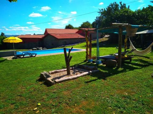 a playground in a yard next to a pool at Village Minhoure in Felgueiras