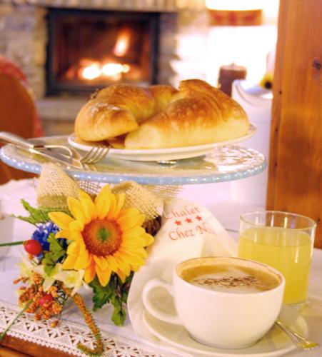 a table with a plate of bread and a cup of coffee at Chalet Chez Nous in Sauze dʼOulx
