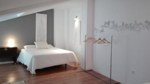 a white bedroom with a bed and a dresser in it at TOLETUM low cost LOFTS diáfanos o 2dormitorios PARKING Municipal Gratis al aire libre a 100m in Toledo