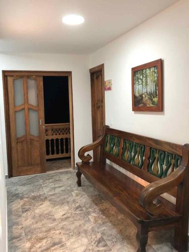 a wooden bench in a room with a door at 40 Amigos Hotel in Jardin