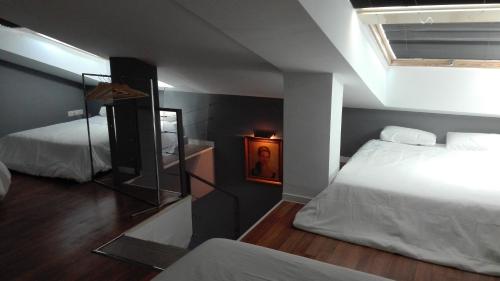 a small bedroom with two beds and a mirror at TOLETUM low cost LOFTS diáfanos o 2dormitorios PARKING Municipal Gratis al aire libre a 100m in Toledo