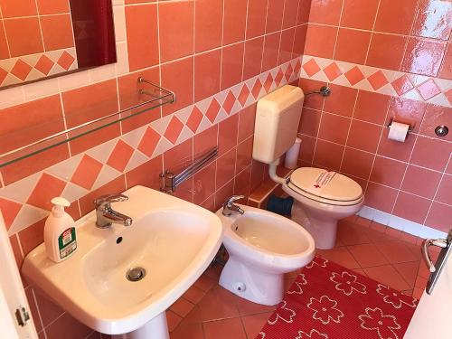uma casa de banho com um lavatório e um WC em Antonio Apartments em Trogir