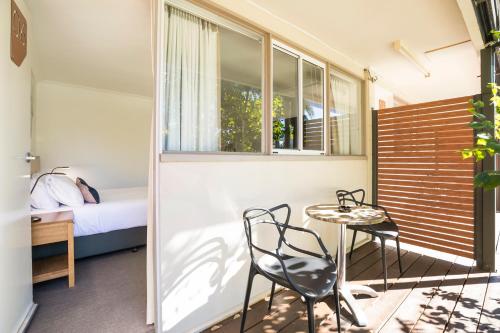 a room with a bed and a table and chairs at Nightcap at Golden Beach Tavern in Caloundra