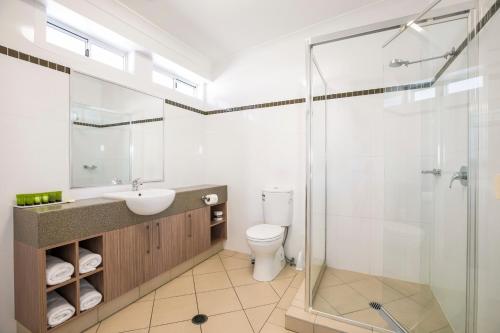 a bathroom with a shower and a sink and a toilet at Nightcap at Golden Beach Tavern in Caloundra
