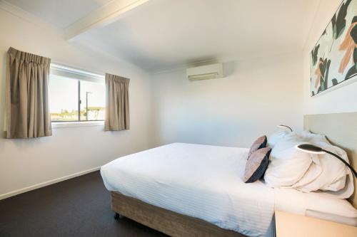 a bedroom with a bed and a window at Nightcap at Golden Beach Tavern in Caloundra