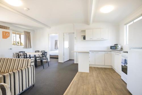 a kitchen and a living room with a table at Nightcap at Golden Beach Tavern in Caloundra