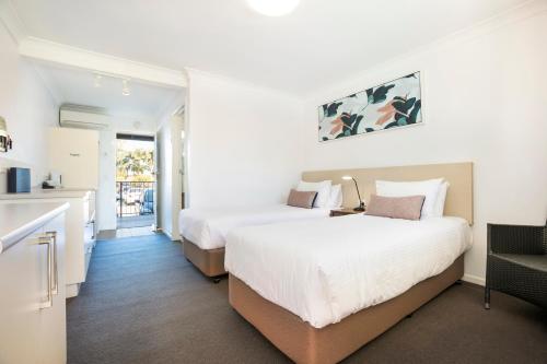 a hotel room with two beds and a kitchen at Nightcap at Golden Beach Tavern in Caloundra