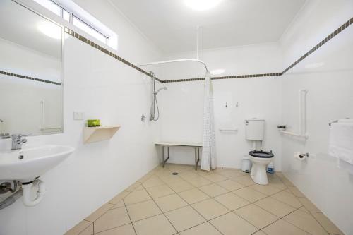 a white bathroom with a sink and a toilet at Nightcap at Golden Beach Tavern in Caloundra