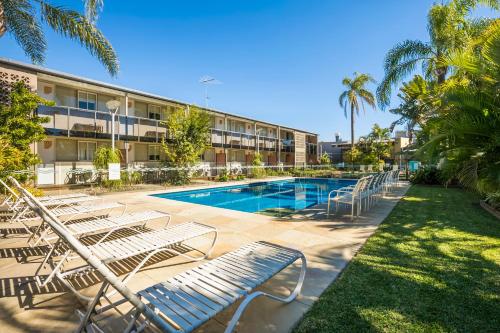 a hotel with a swimming pool and lounge chairs at Nightcap at Golden Beach Tavern in Caloundra