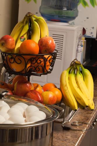 a bowl of fruit with bananas and oranges on a counter at Days Inn by Wyndham Surrey in Surrey