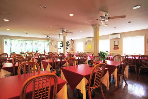a dining room with red tables and chairs at Mt Fuji B&B PENSION LE LAGON in Yamanakako