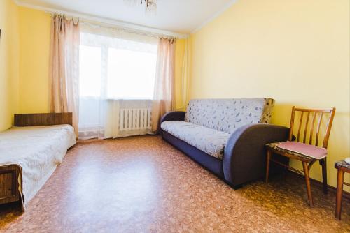 a living room with a couch and a window at Dekabrist Apartment at leningradskaya 24 in Chita