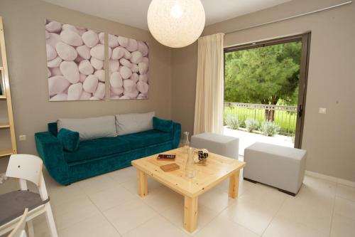 a living room with a green couch and a table at G.Living 365 in Ayia Evfimia