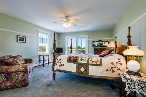 a bedroom with a bed and a chair in it at Payne's Harbor View Inn in New Shoreham