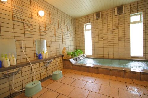 a bathroom with a tub and a toilet in it at Pension Aroma Herbs Le Lagon in Yamanakako