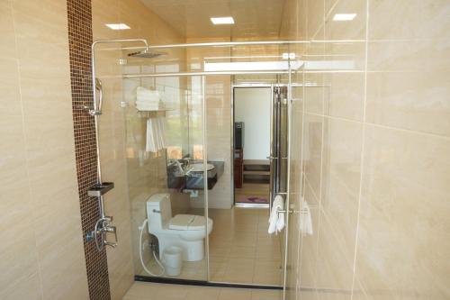 a bathroom with a toilet and a glass shower at Coral B&B in Hengchun