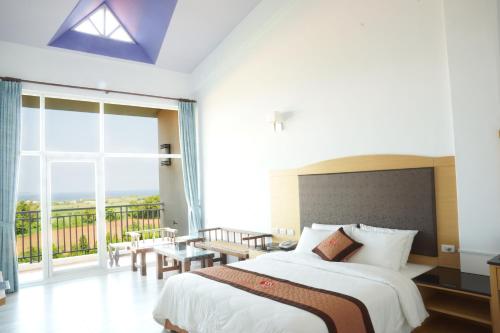 a bedroom with a large bed and a large window at Coral B&B in Hengchun