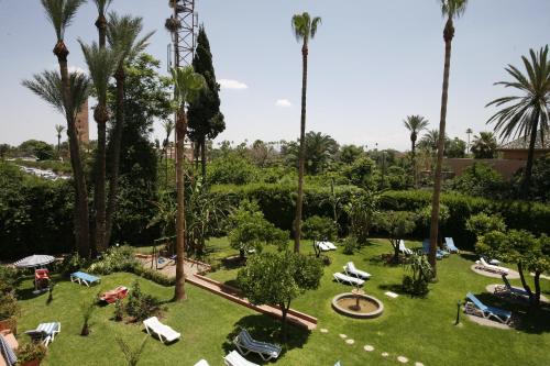 an aerial view of a park with palm trees and lounge chairs at Chems Hotel in Marrakech