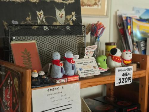 a shelf with knitted animals and signs on it at Fureai No Yado Yasuragi in Nozawa Onsen