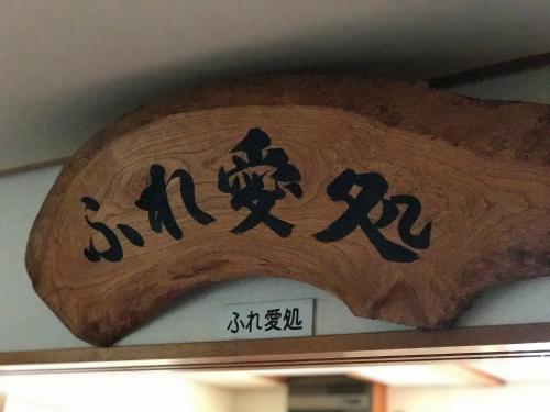 a wooden sign with chinese writing on a wall at Fureai No Yado Yasuragi in Nozawa Onsen