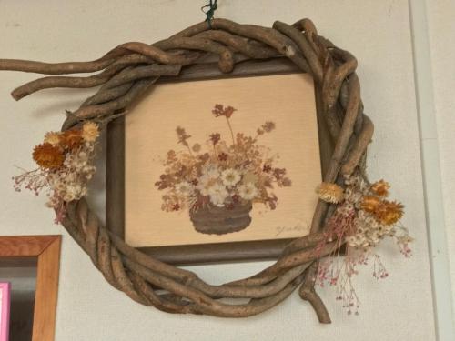 a wreath with a vase of flowers on a wall at Fureai No Yado Yasuragi in Nozawa Onsen