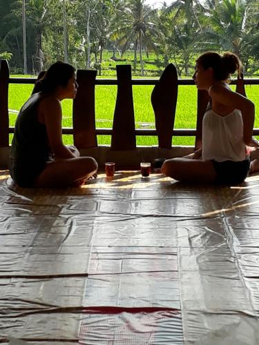 a group of three women sitting on the floor doing yoga at The New Orlinds Guest House in Wonosari