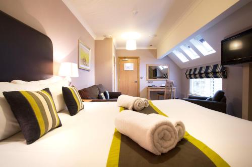 a bedroom with a large bed with towels on it at Breckland Lodge in Attleborough