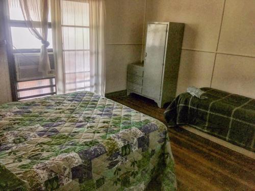 a bedroom with a bed and a dresser and a window at Royal Carrangarra Hotel in Tambo