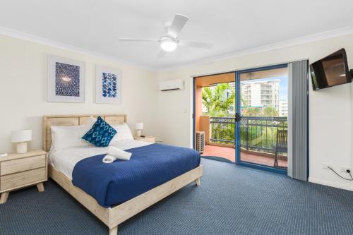 um quarto com uma cama azul e uma varanda em Bella Mare Coolangatta Beachside Apartments em Gold Coast