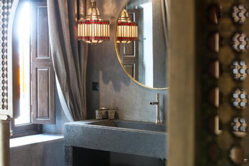 a bathroom with a sink and a mirror at Dar Kandi in Marrakech