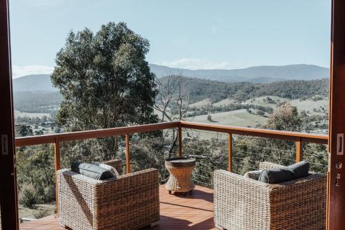 a balcony with chairs and a view of the mountains at Kangaroo Ridge Retreat in Healesville