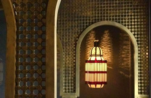 a chandelier hanging from a wall in a building at Dar Kandi in Marrakech