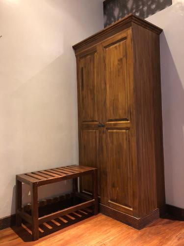 a wooden cabinet and a bench in a room at Hotel Veneto De Vigan in Vigan