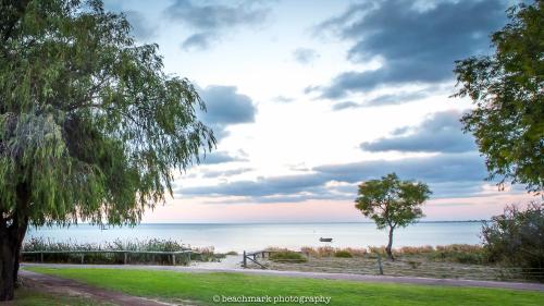 a view of the ocean from a park with a tree at Whalers Cove Villas in Dunsborough