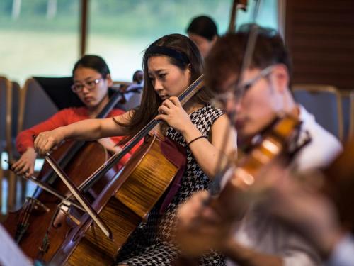 a group of people playing violins in a orchestra at Okushiga Kogen Hotel in Yamanouchi
