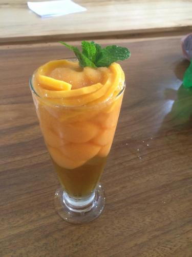 a drink in a glass on a wooden table at Green Hill Hostel & Tour in Ha Giang