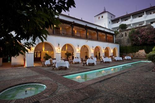 a hotel with a swimming pool in front of a building at Parador de Guadalupe in Guadalupe
