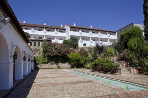a courtyard with a large white building and some plants at Parador de Guadalupe in Guadalupe