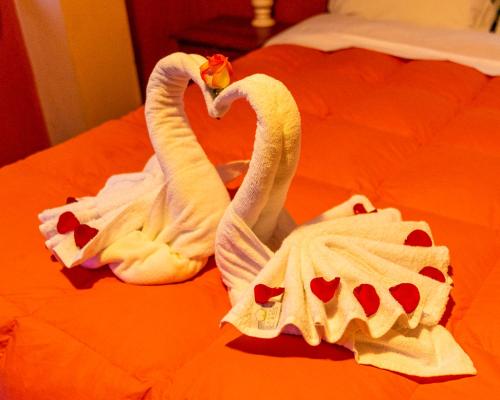 two towels shaped like swans sitting on a bed at Peru Quechua's Lodge Ollantaytambo in Ollantaytambo