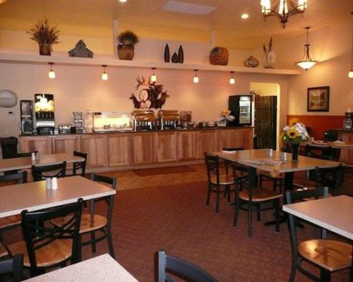 a restaurant with tables and chairs and a counter at Trails End Motel Sheridan in Sheridan