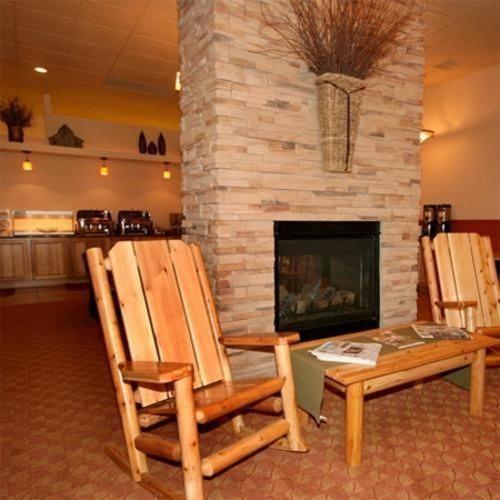 two chairs and a table in front of a fireplace at Trails End Motel Sheridan in Sheridan
