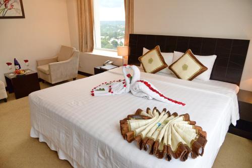 a hotel room with a large white bed with at Sai Gon Ban Me Hotel in Buon Ma Thuot