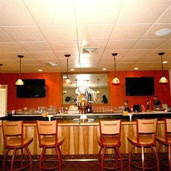 a bar with wooden chairs in a restaurant at Trails End Motel Sheridan in Sheridan