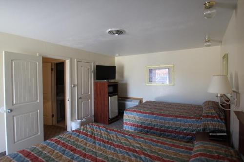 a hotel room with a bed and a television at Trails End Motel Sheridan in Sheridan