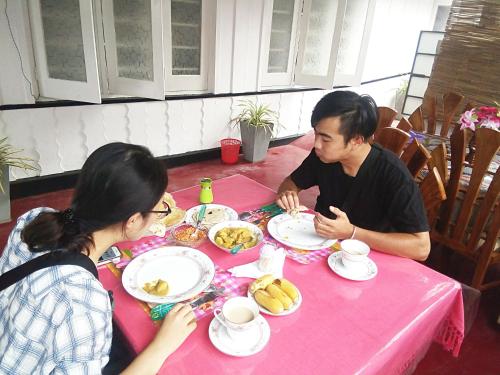 a man and woman sitting at a table eating food at Gloriya Mathews in Negombo