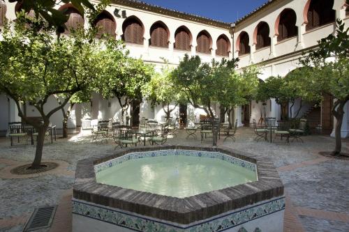 a pool in a courtyard with trees and tables at Parador de Guadalupe in Guadalupe