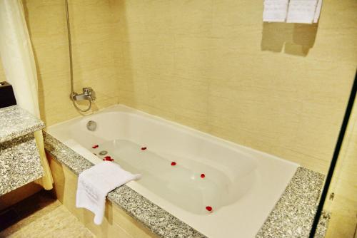a bathroom with a bath tub with red dots on it at Sai Gon Ban Me Hotel in Buon Ma Thuot