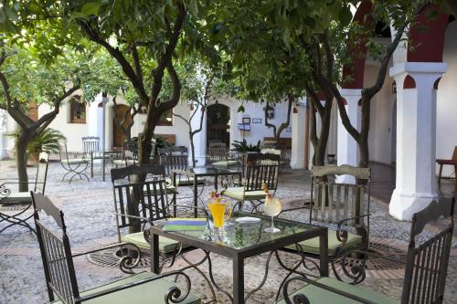 an outdoor patio with tables and chairs and trees at Parador de Guadalupe in Guadalupe