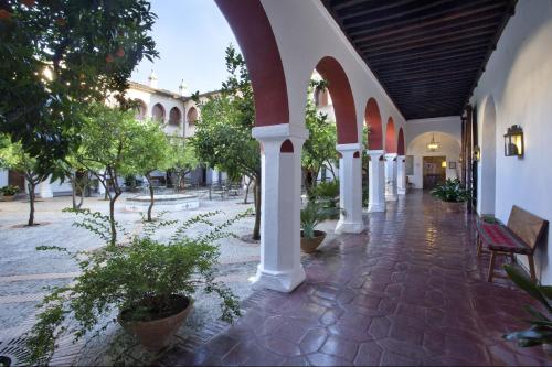 an empty courtyard with trees and a building at Parador de Guadalupe in Guadalupe