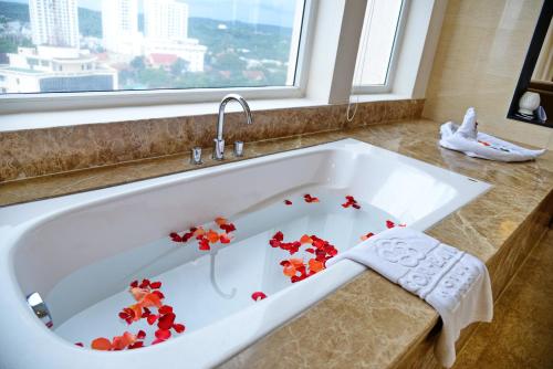 a bath tub with red flowers in it at Sai Gon Ban Me Hotel in Buon Ma Thuot